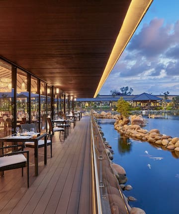 a restaurant with tables and chairs on a deck overlooking a body of water