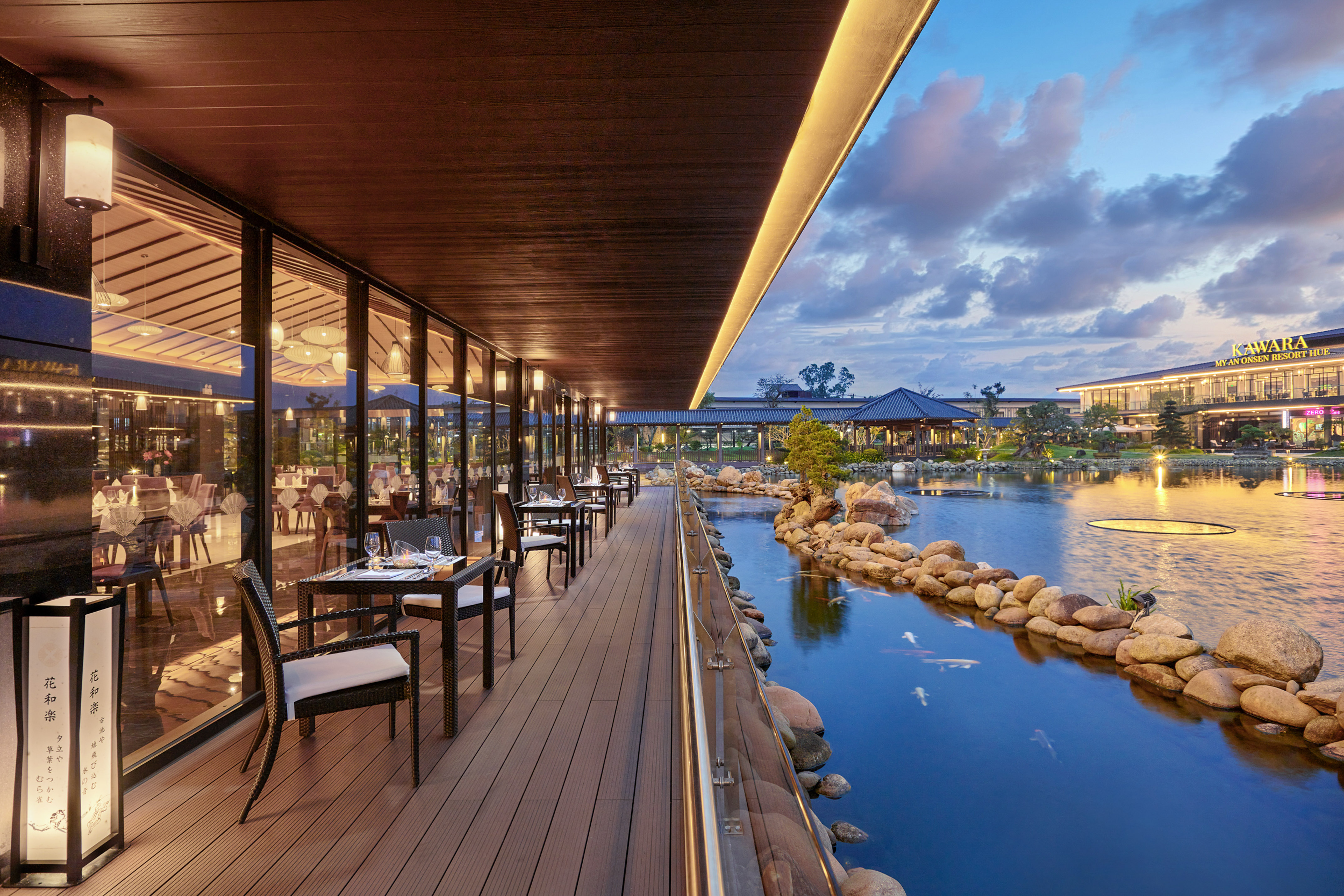Outdoor dining patio by koi pond at Kawara My An Onsen Resort, evening.