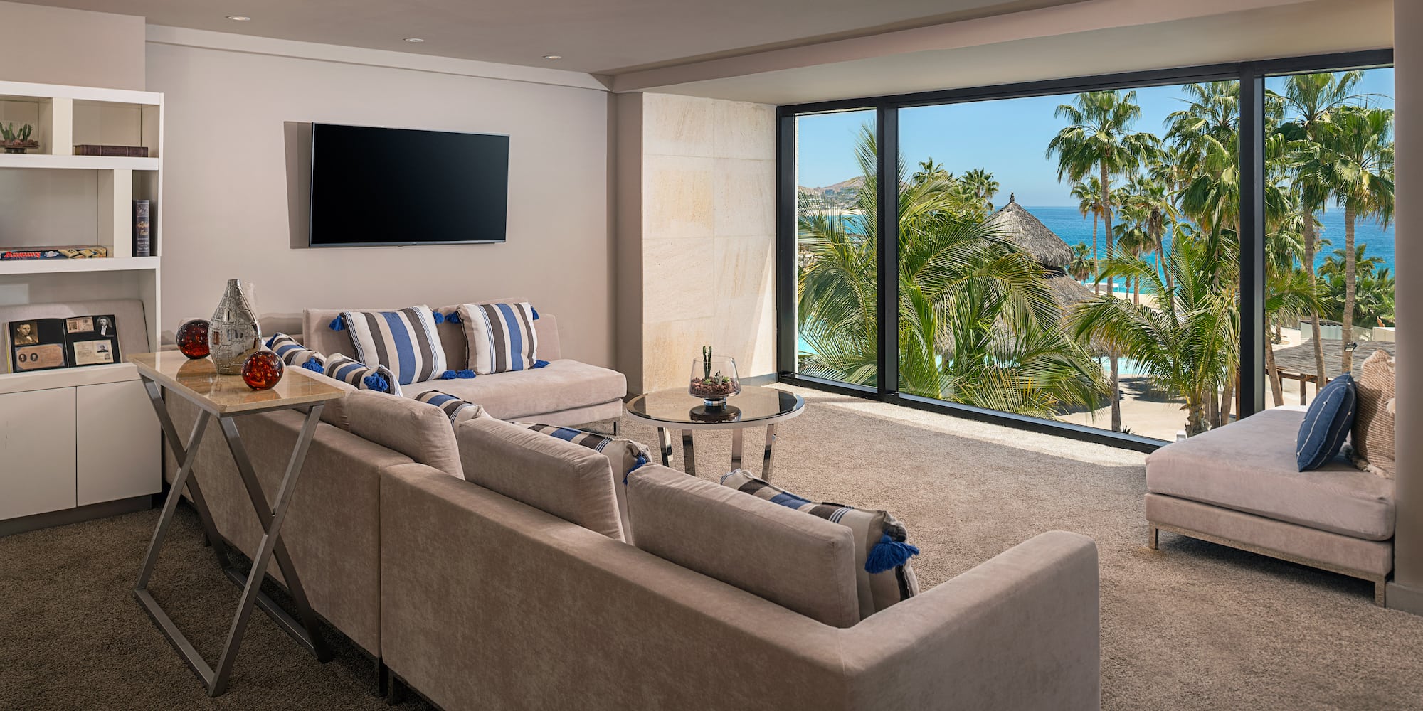 a living room with a large window overlooking a beach