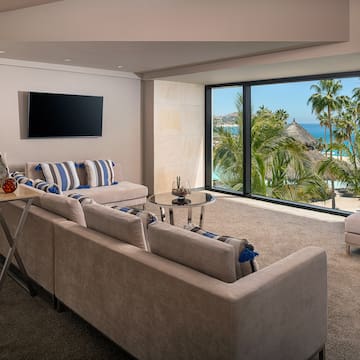 a living room with a large window overlooking a beach