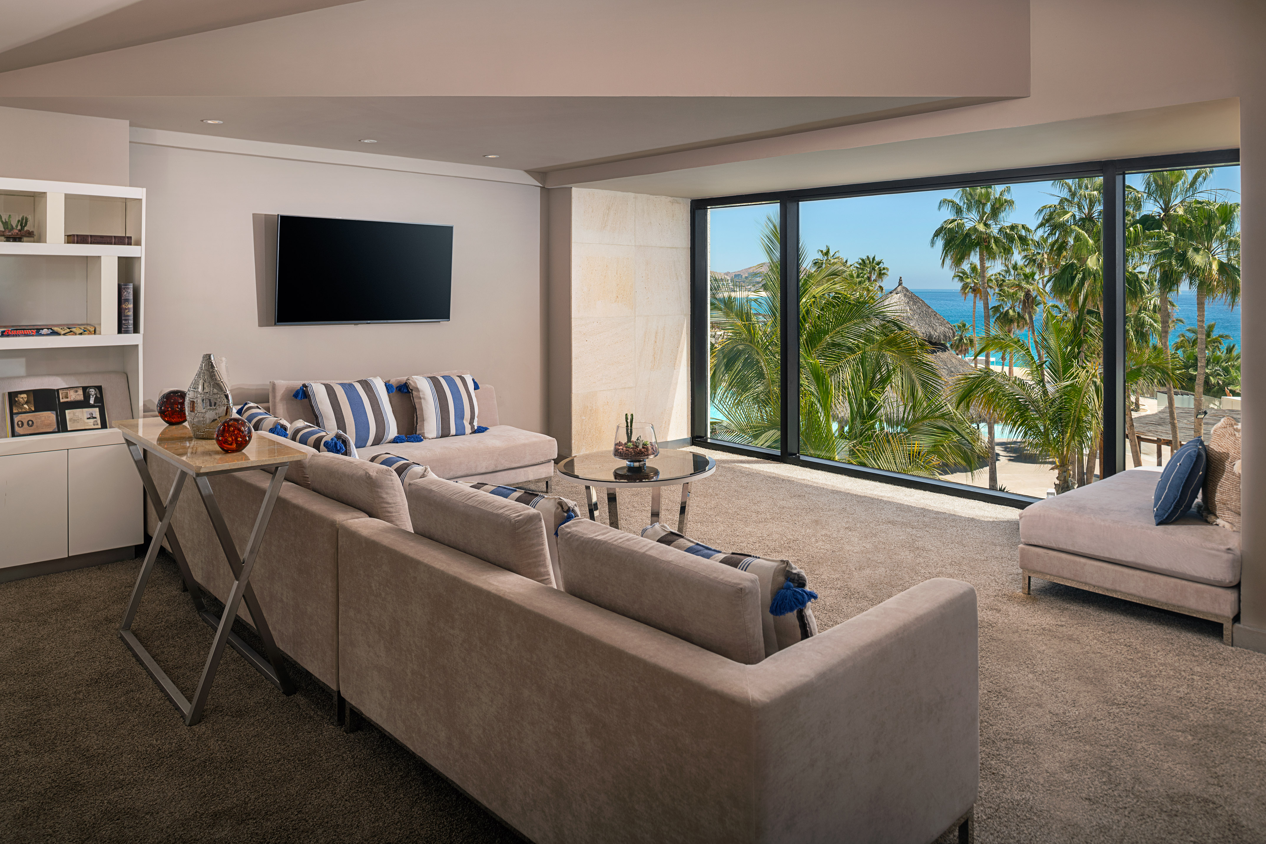 a living room with a large window overlooking a beach