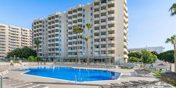 a pool with lounge chairs and a building