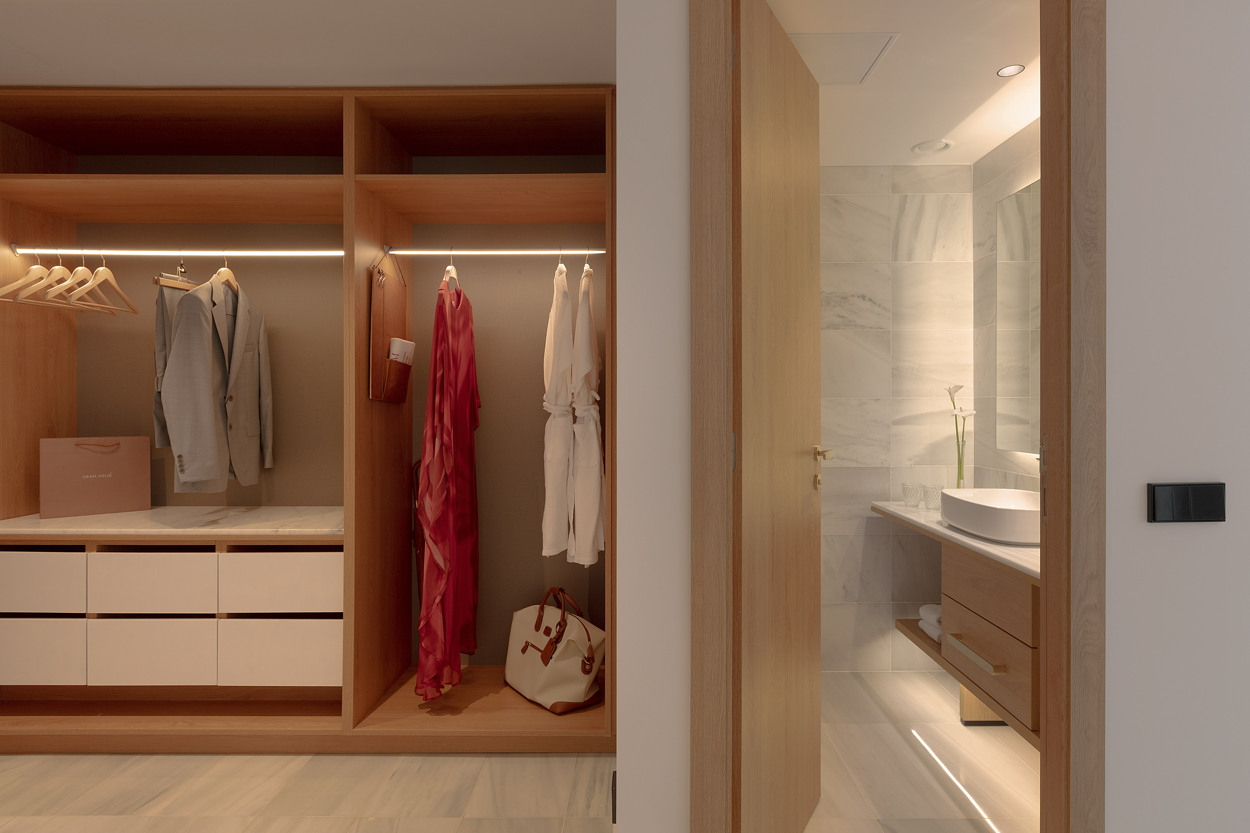 Stylish built-in wooden wardrobe, LED lighting, luxury bathroom vanity.