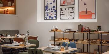 a room with tables and chairs and art on the wall