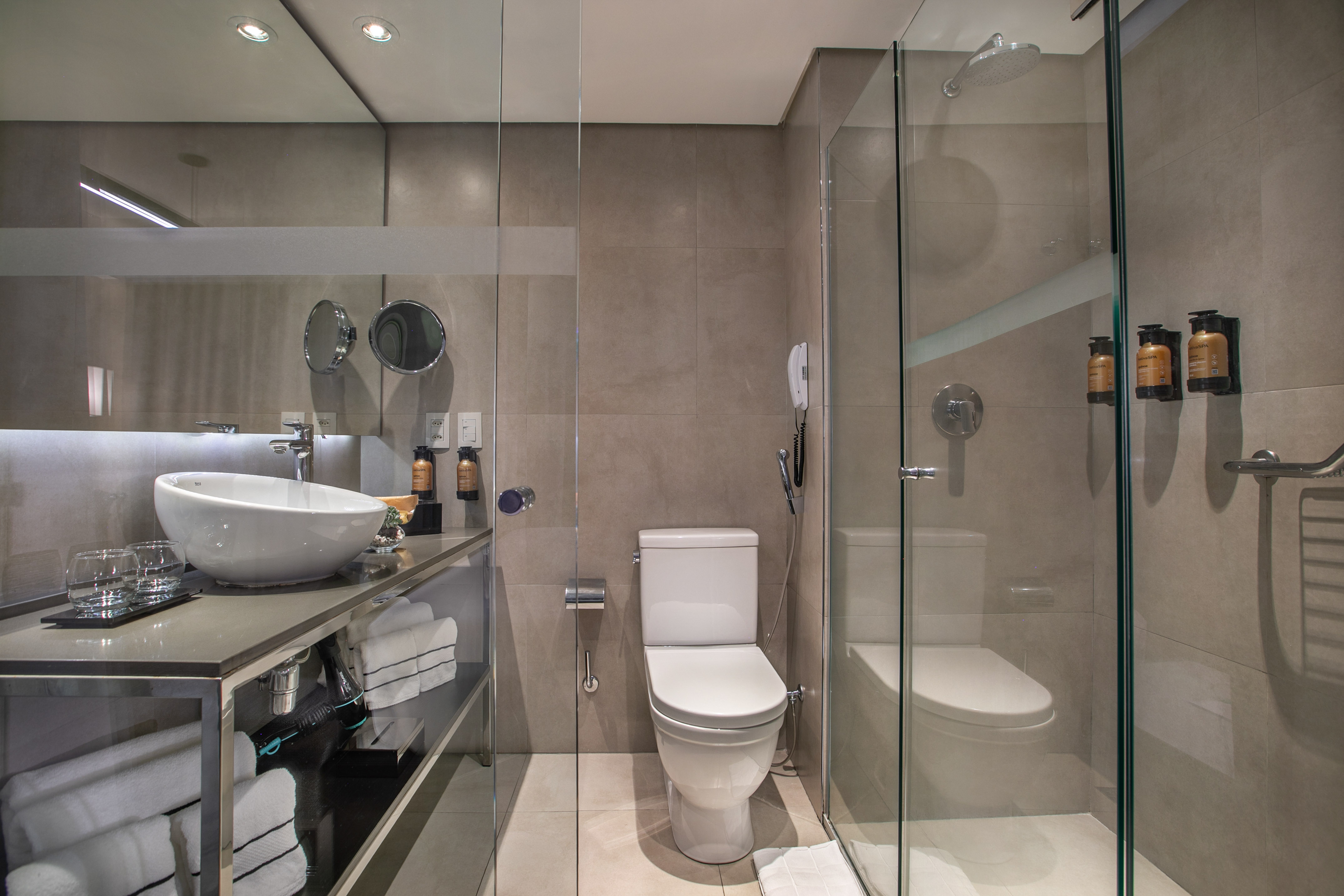 Modern gray tiled bathroom with glass shower enclosure, white toilet, and vessel sink vanity. - Grand Premium com Varanda - Meliá Ibirapuera, São Paulo