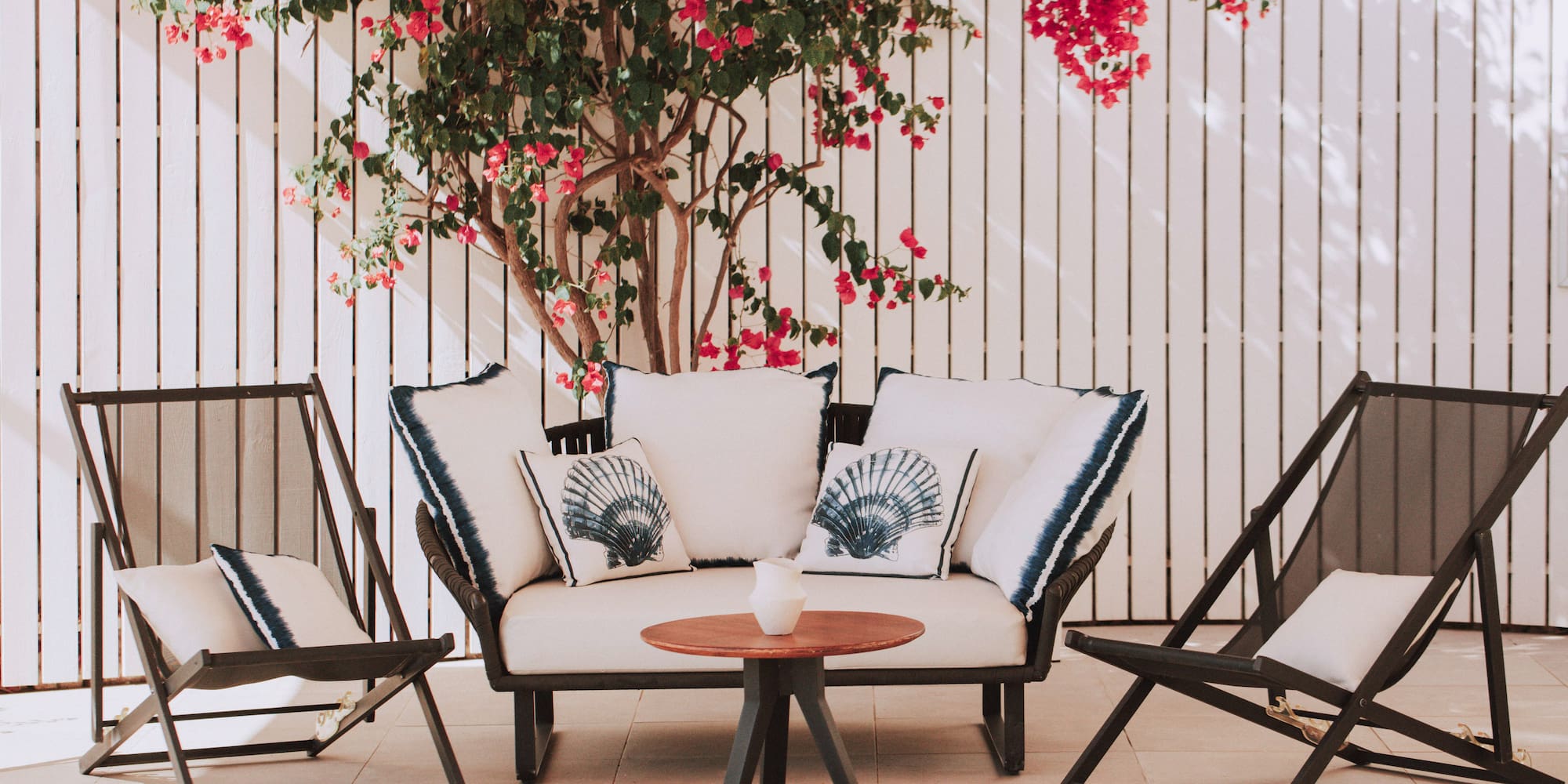 a patio furniture with a tree and flowers