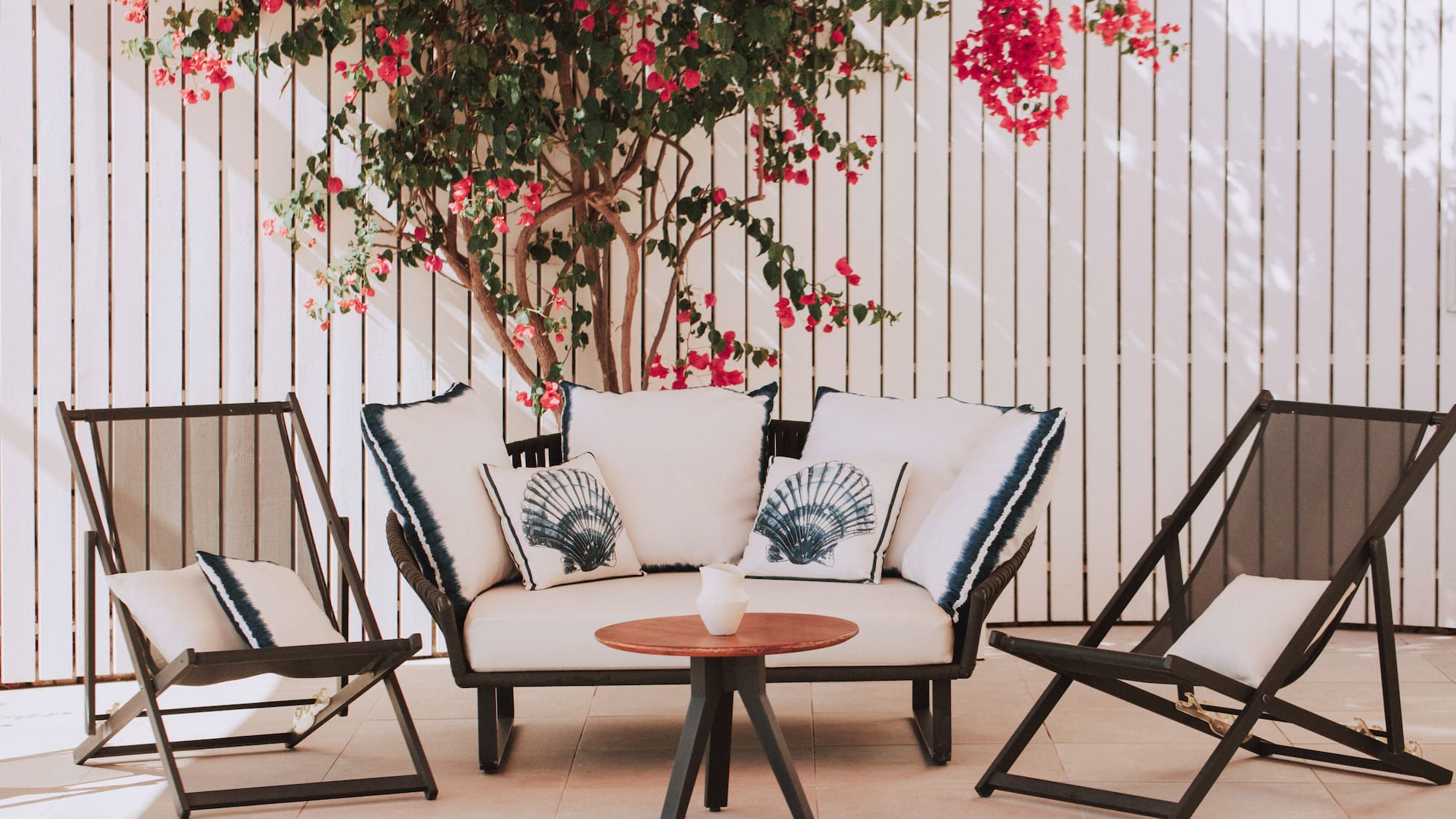 a patio furniture with a tree and flowers