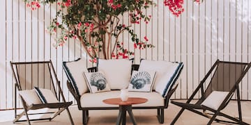 a patio furniture with a tree and flowers