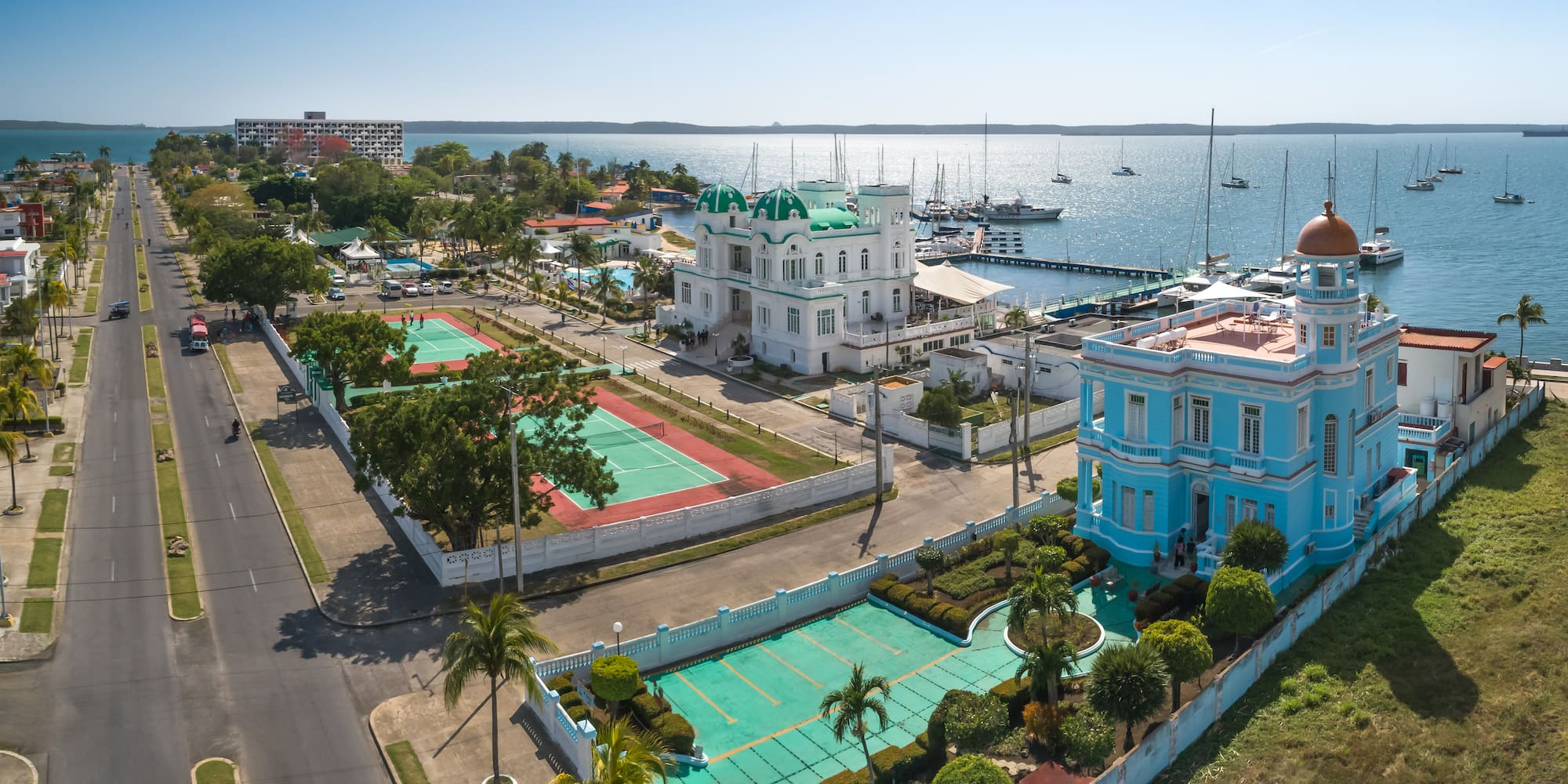 a tennis court and tennis court next to a body of water