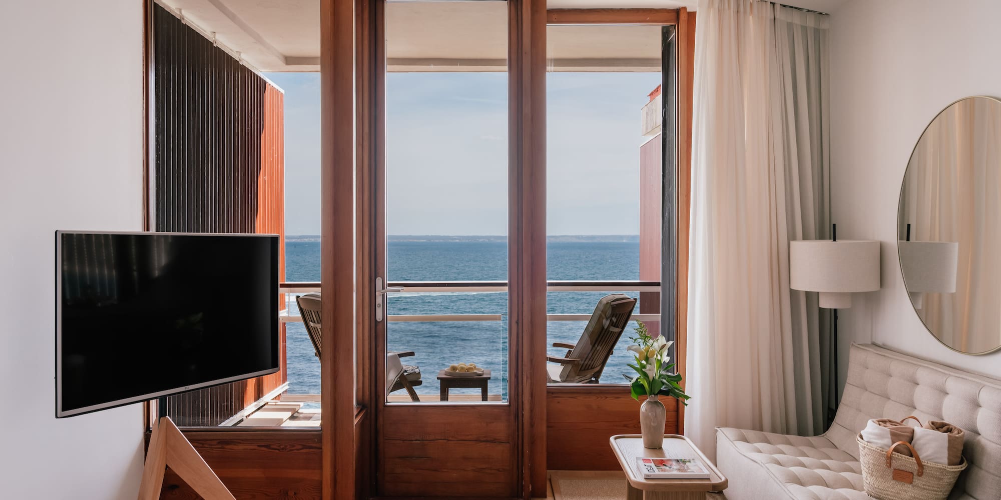 a room with a television and a view of the ocean