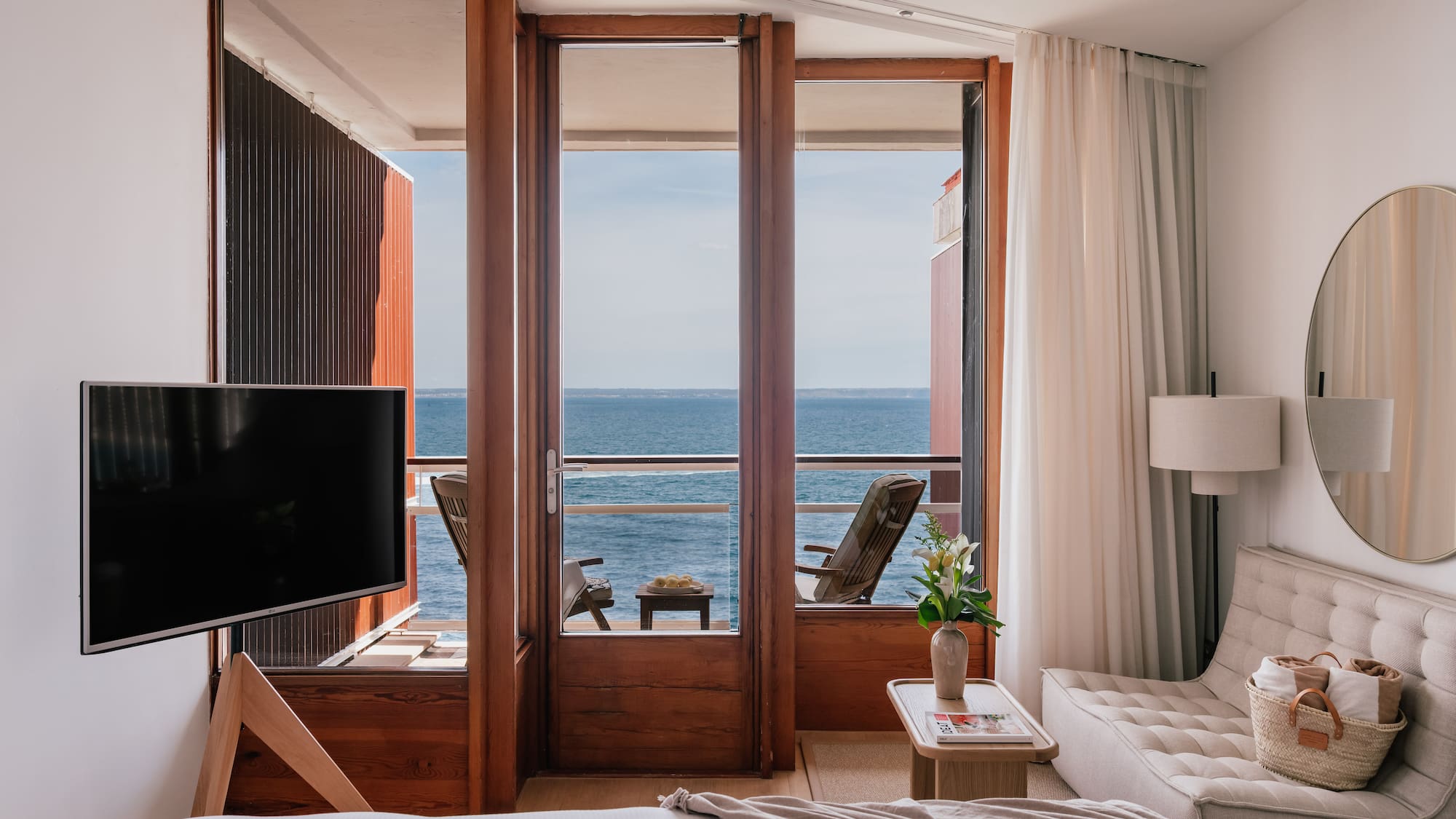 a room with a television and a view of the ocean