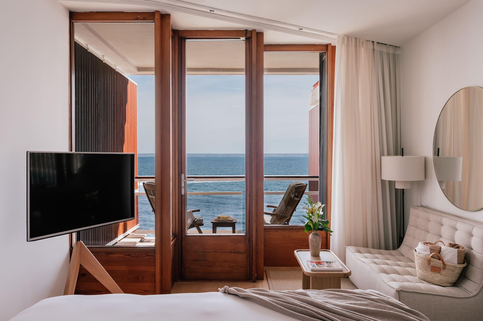a room with a television and a view of the ocean
