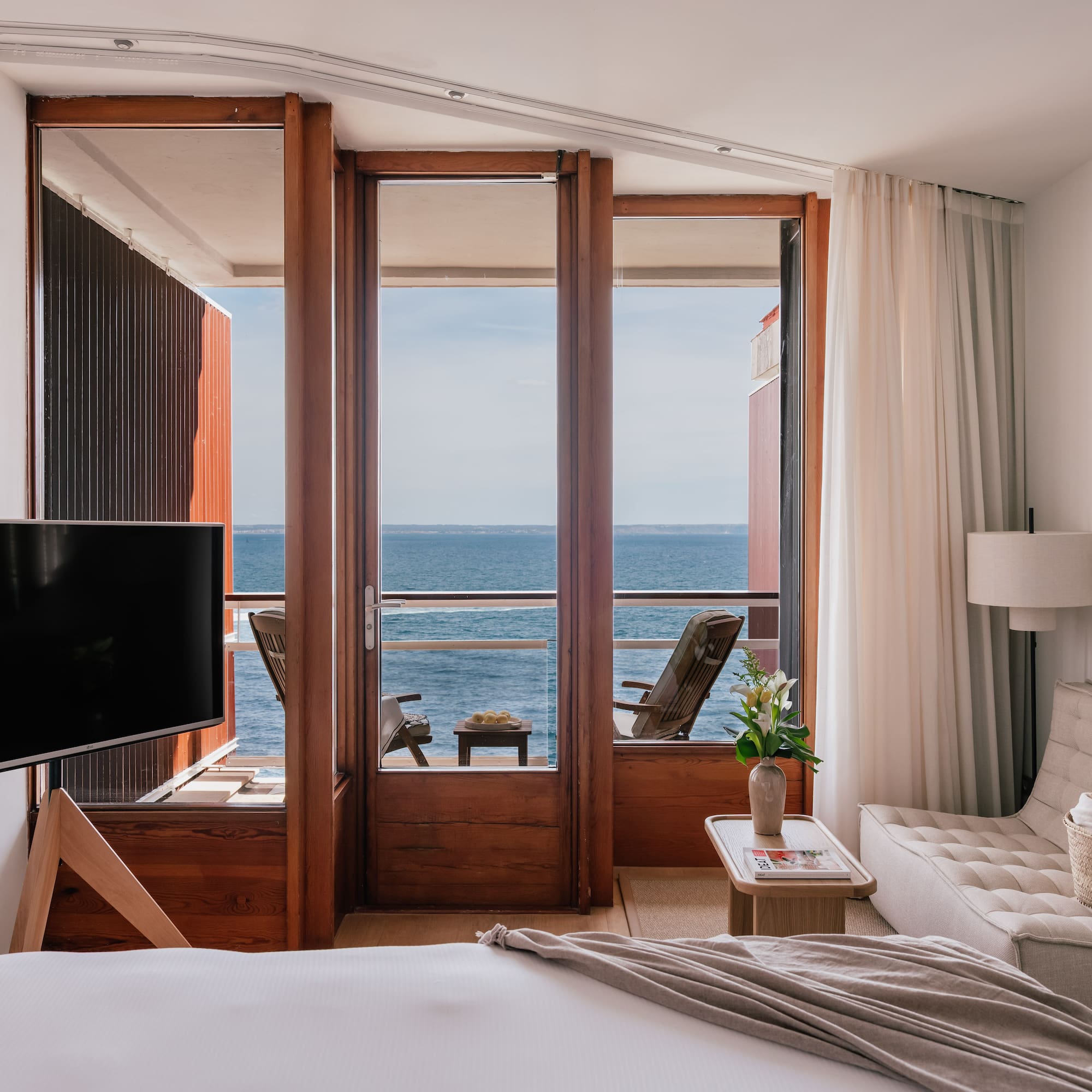 a room with a television and a view of the ocean