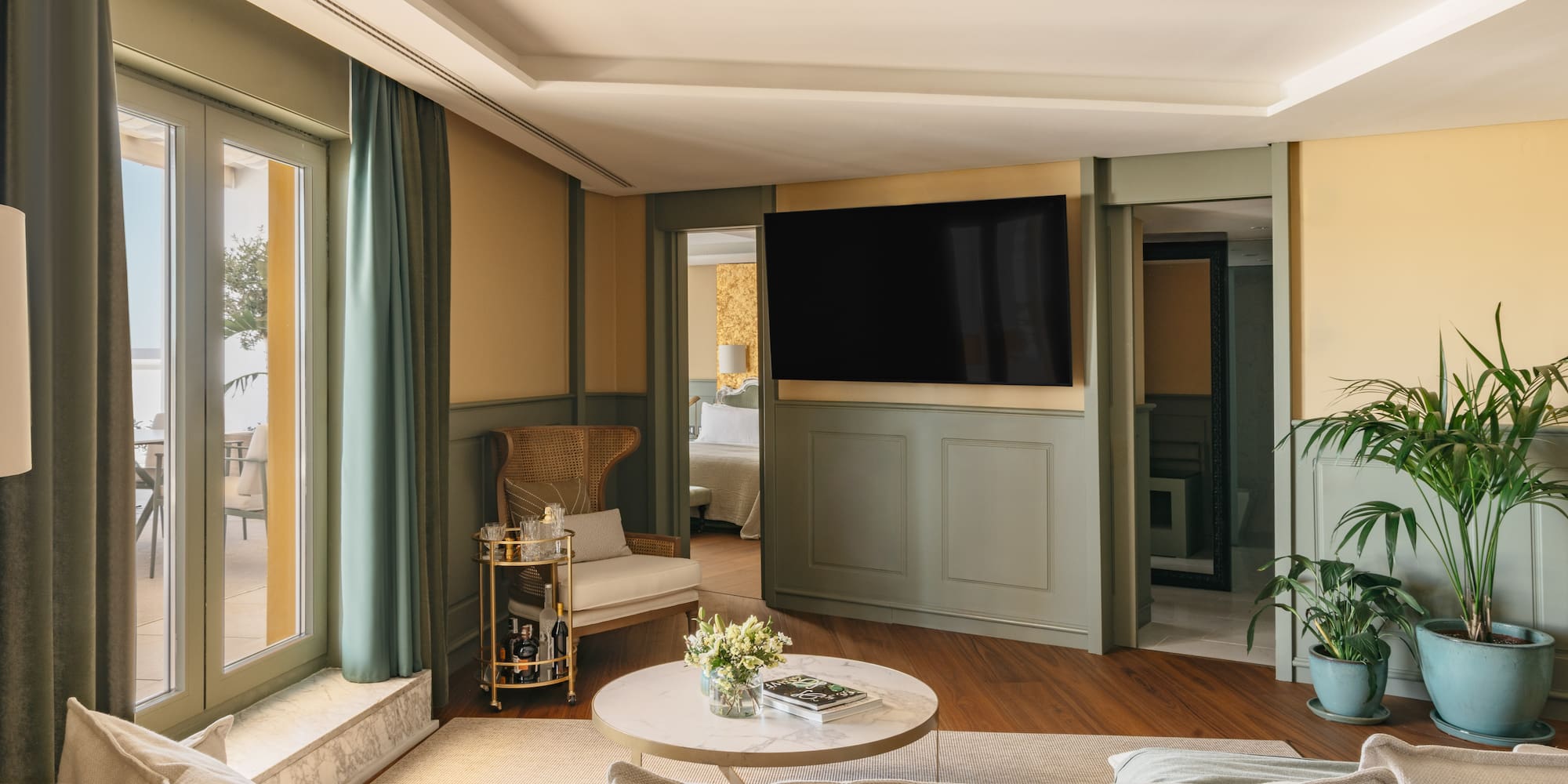 Sala de estar moderna en suite de hotel con terraza, TV y diseño elegante.