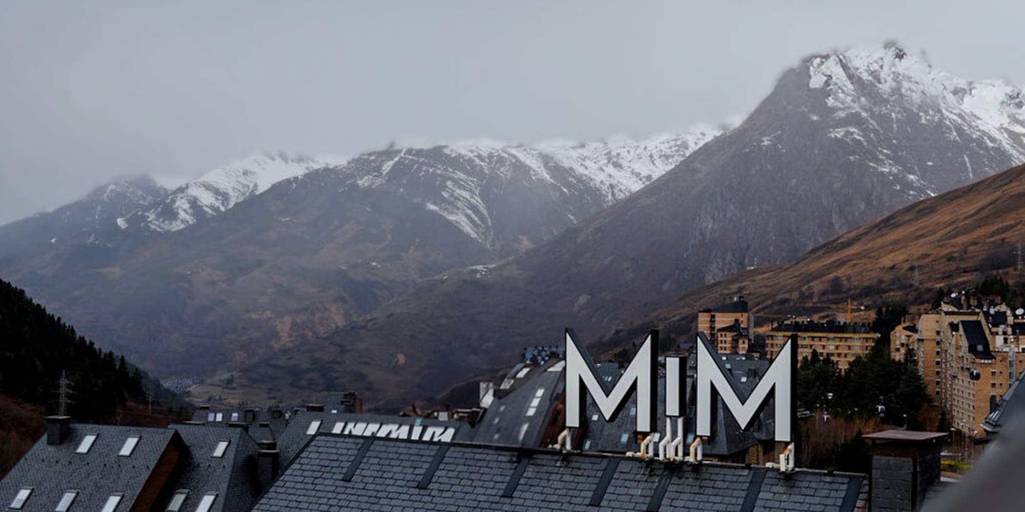 a rooftop of a building with snow covered mountains in the background