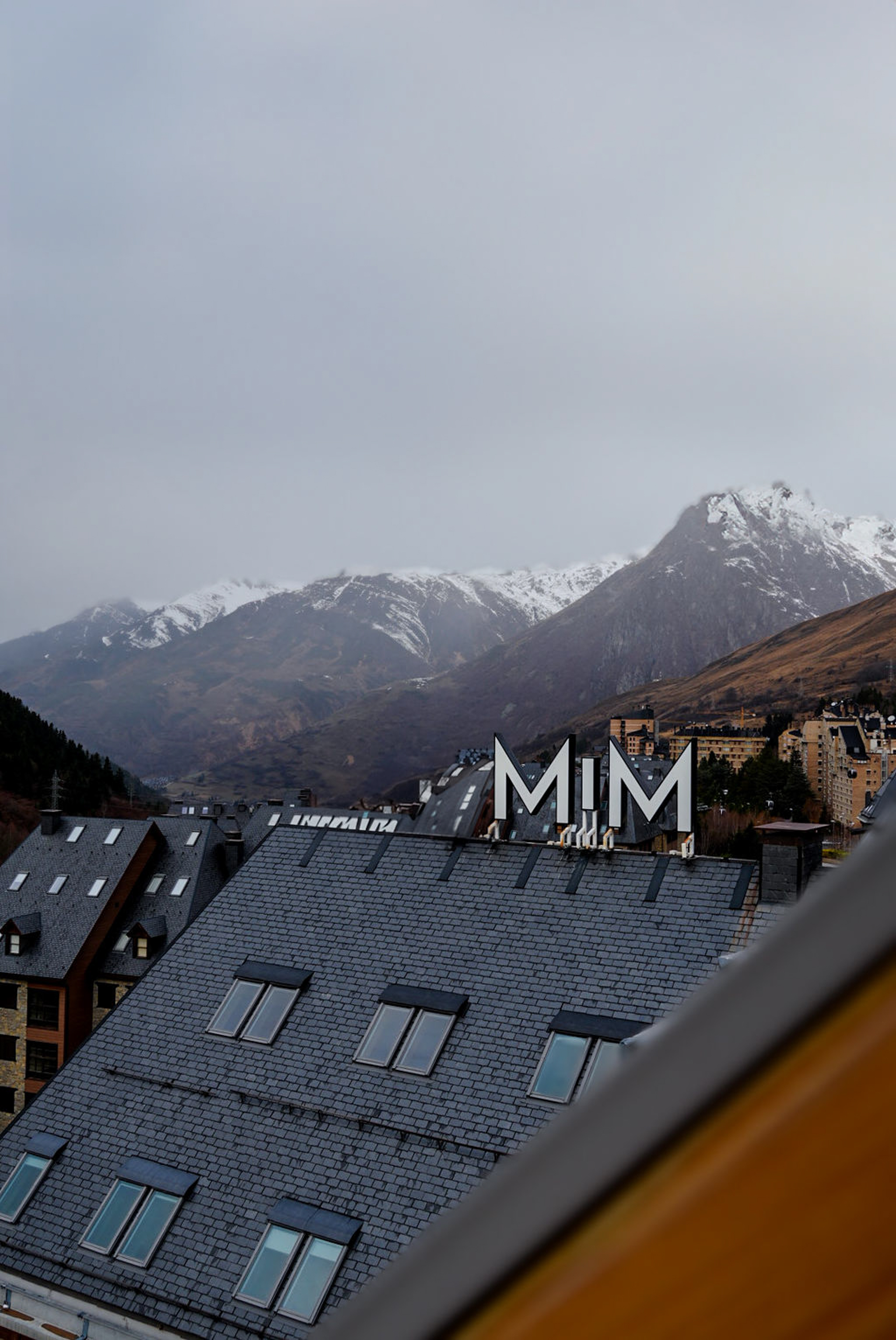 a rooftop of a building with snow covered mountains in the background