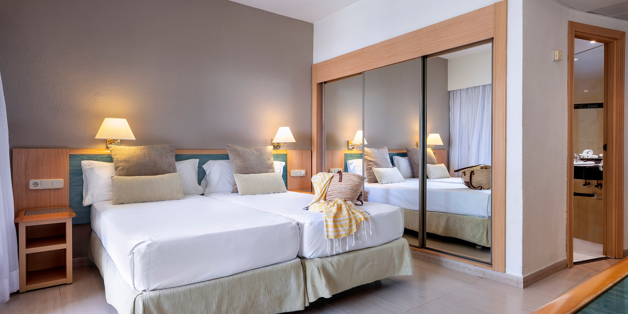 a room with two beds and a mirror