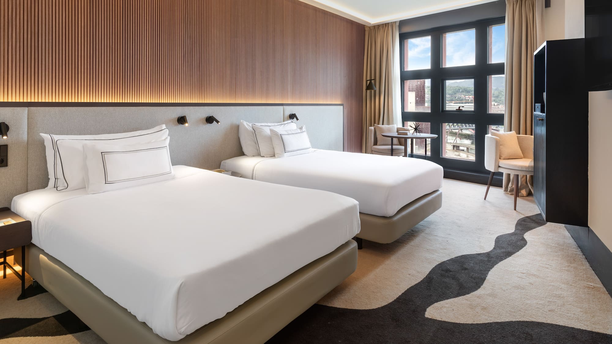 a room with two beds and a chair