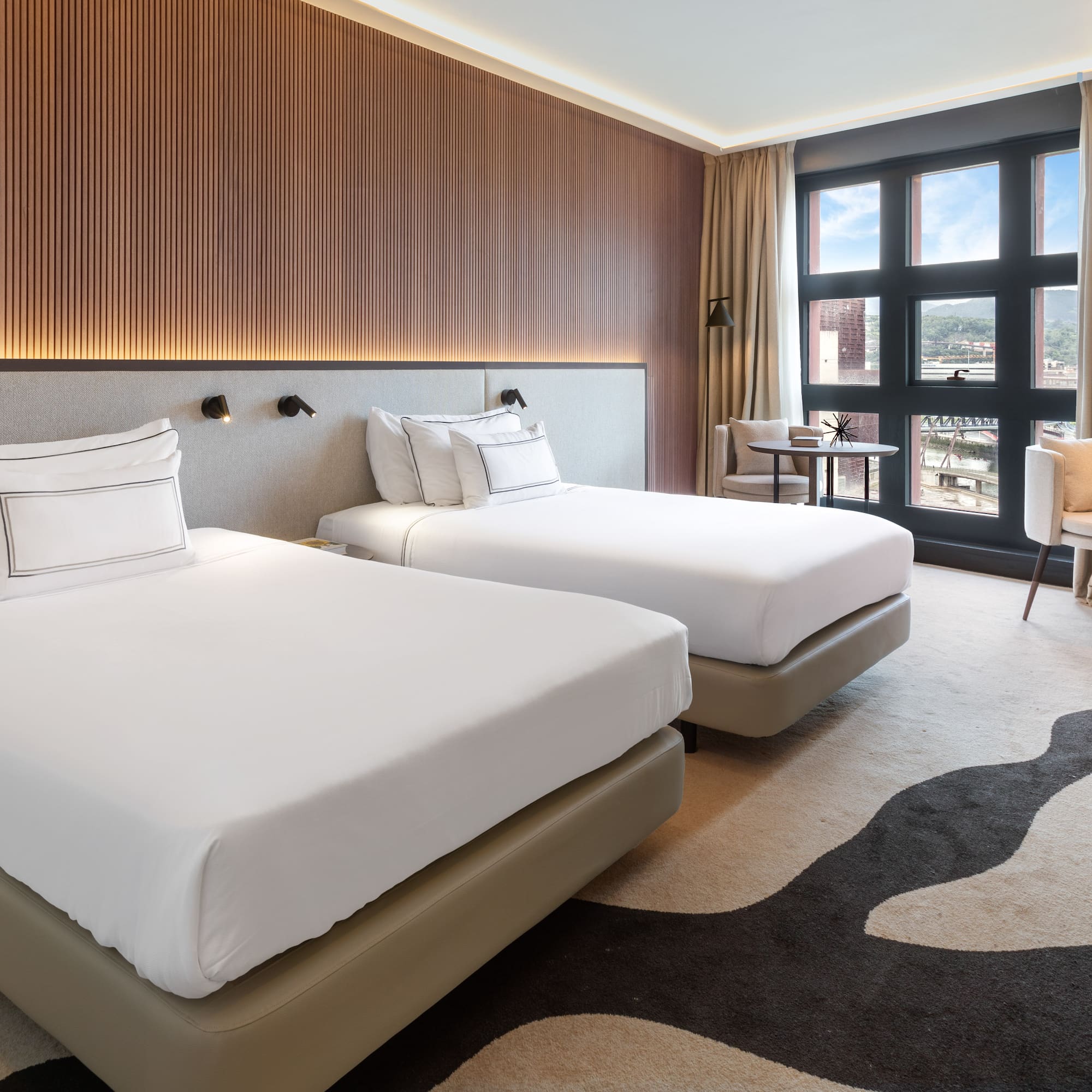 a room with two beds and a chair