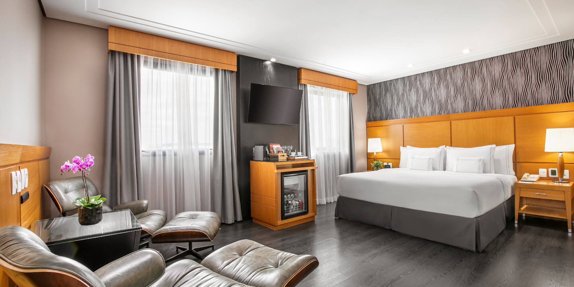 a room with a bed and chairs