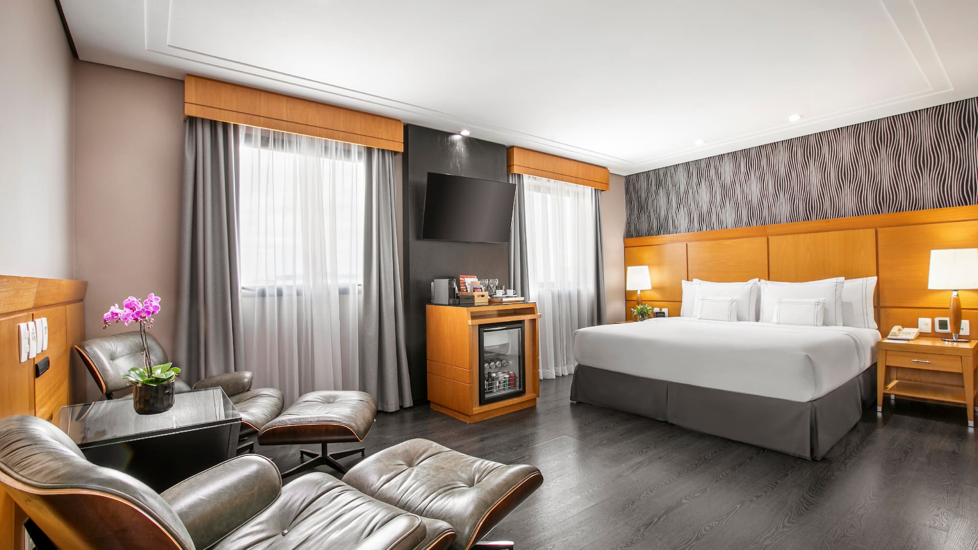 a room with a bed and chairs