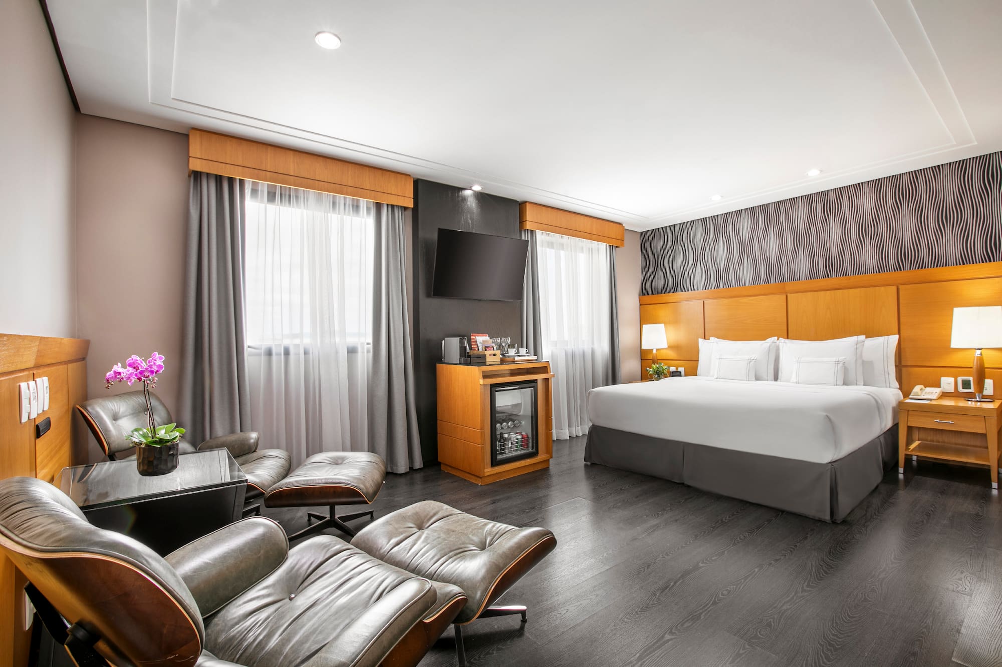 a room with a bed and chairs