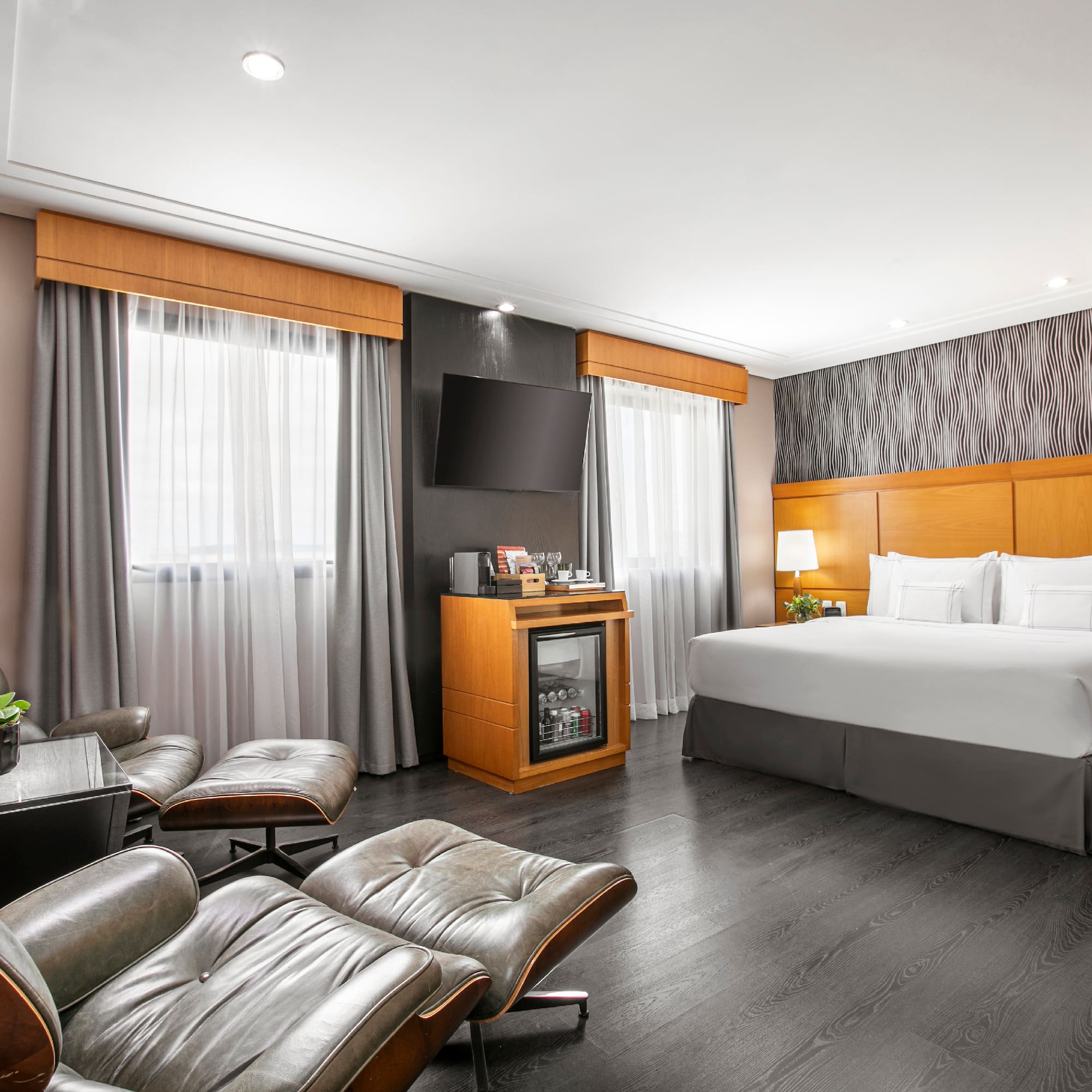 a room with a bed and chairs