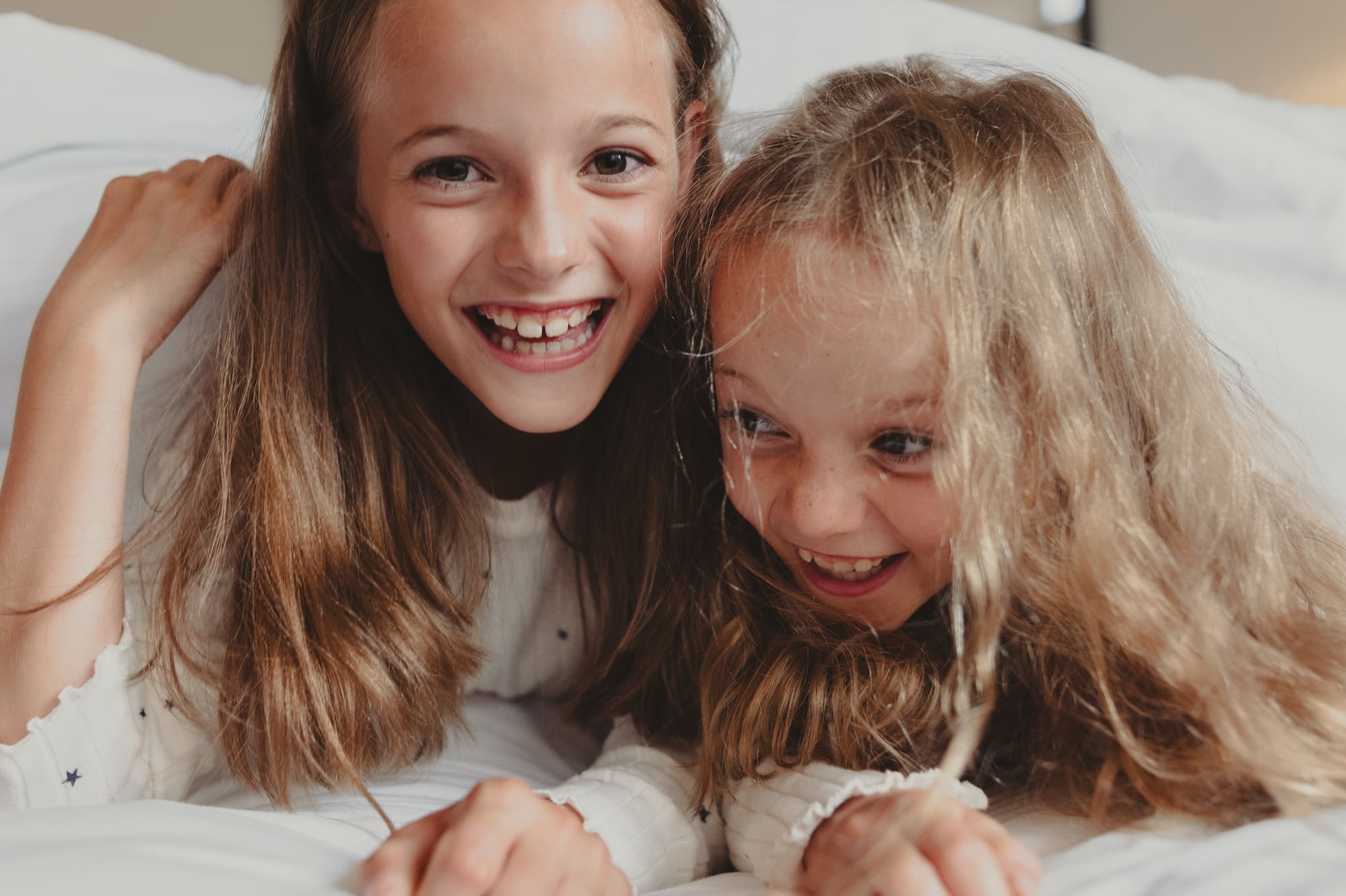 two girls lying on a bed