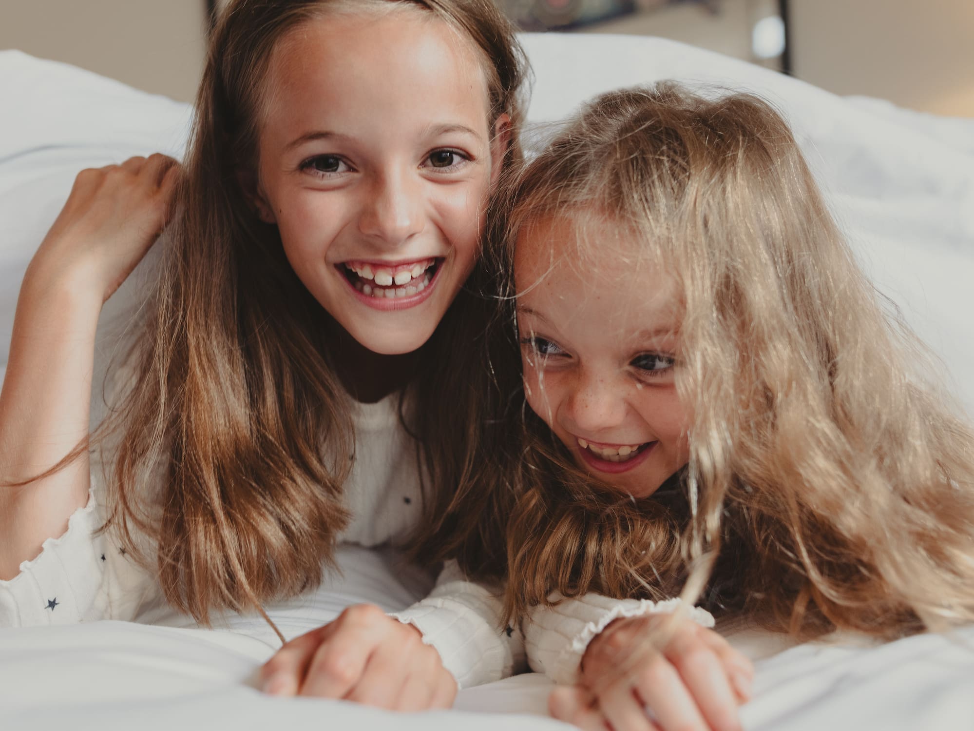 two girls lying on a bed