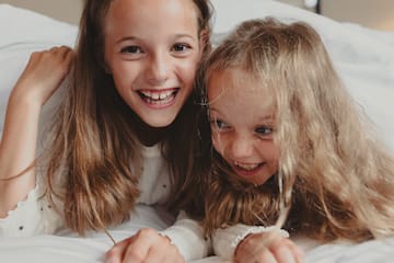two girls lying on a bed