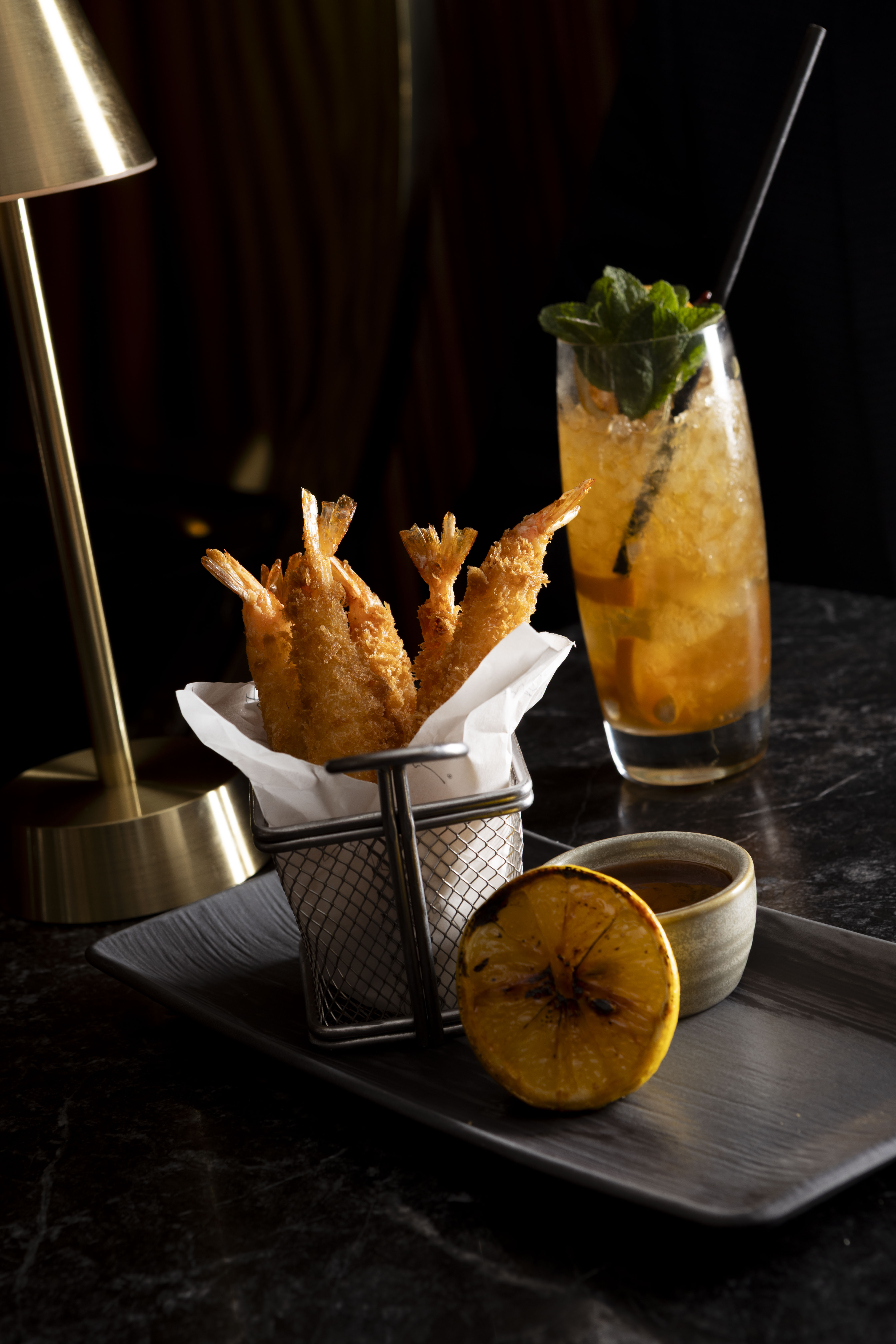 Golden tempura shrimp, grilled lemon, dipping sauce, and a mint cocktail.