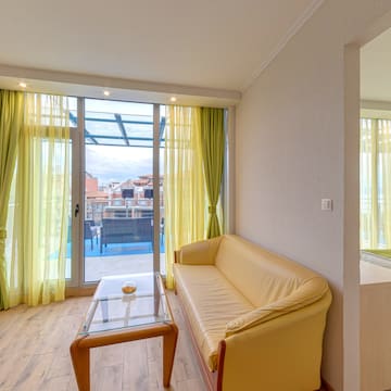 a room with yellow couch and glass table