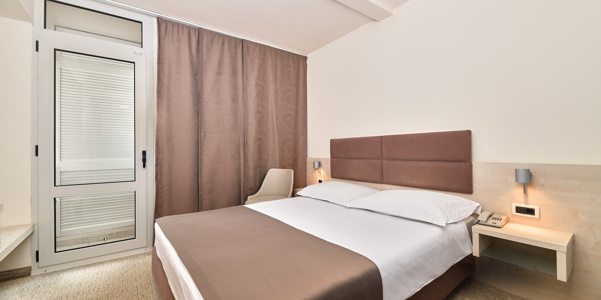 a bed with a brown headboard and a brown curtain