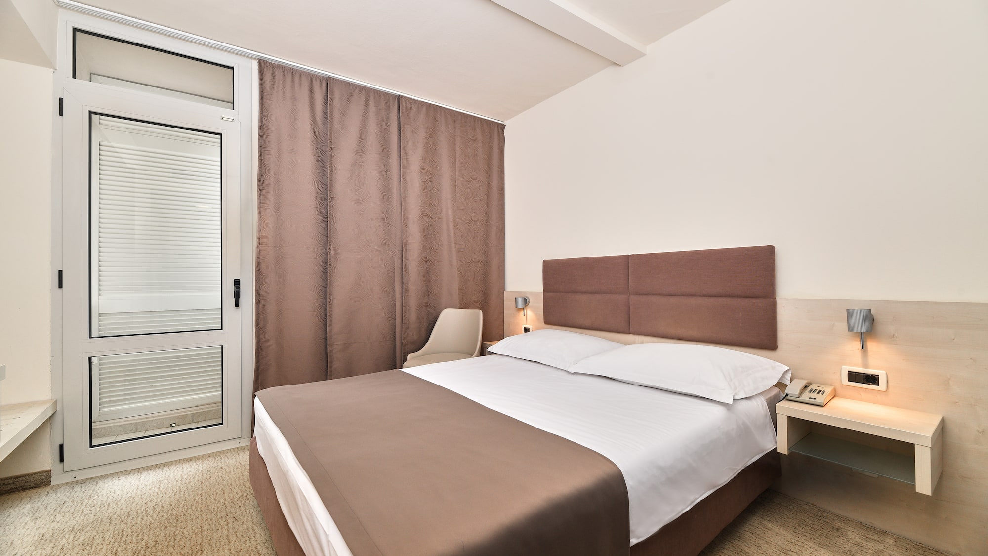 a bed with a brown headboard and a brown curtain
