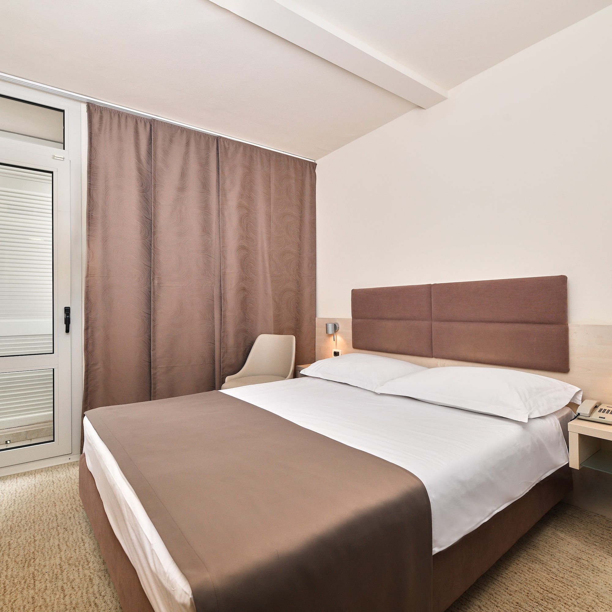 a bed with a brown headboard and a brown curtain