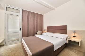 a bed with a brown headboard and a brown curtain