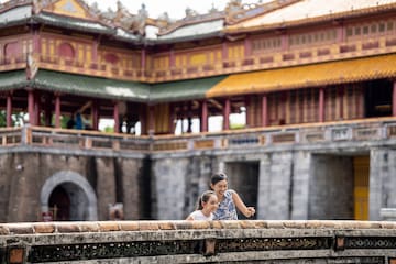 a woman and a girl standing on a wall in front of a building