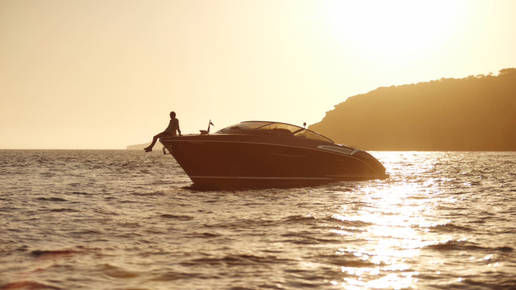 a person sitting on the front of a boat in the water