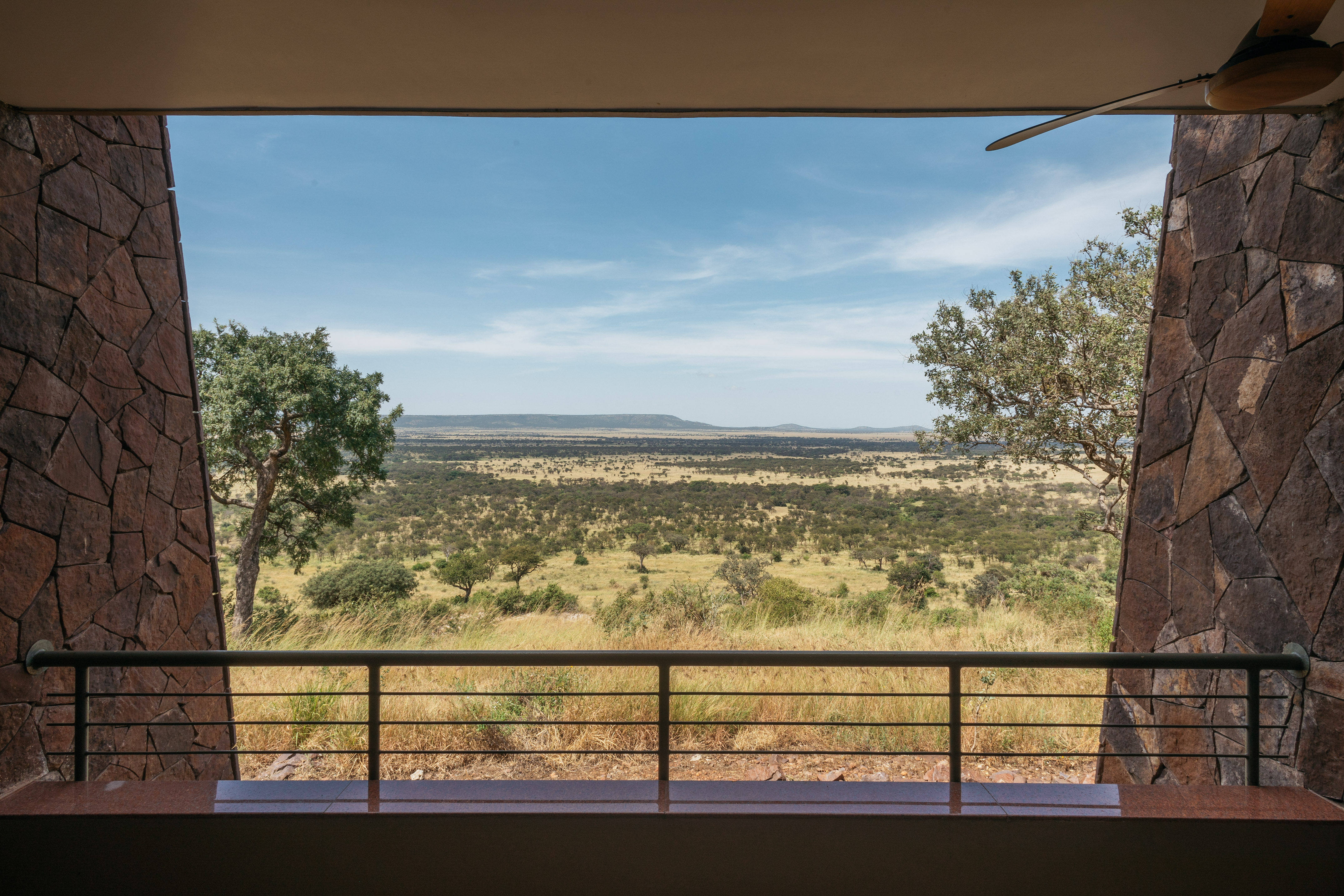 Safari lodge balcony with expansive African savanna view.