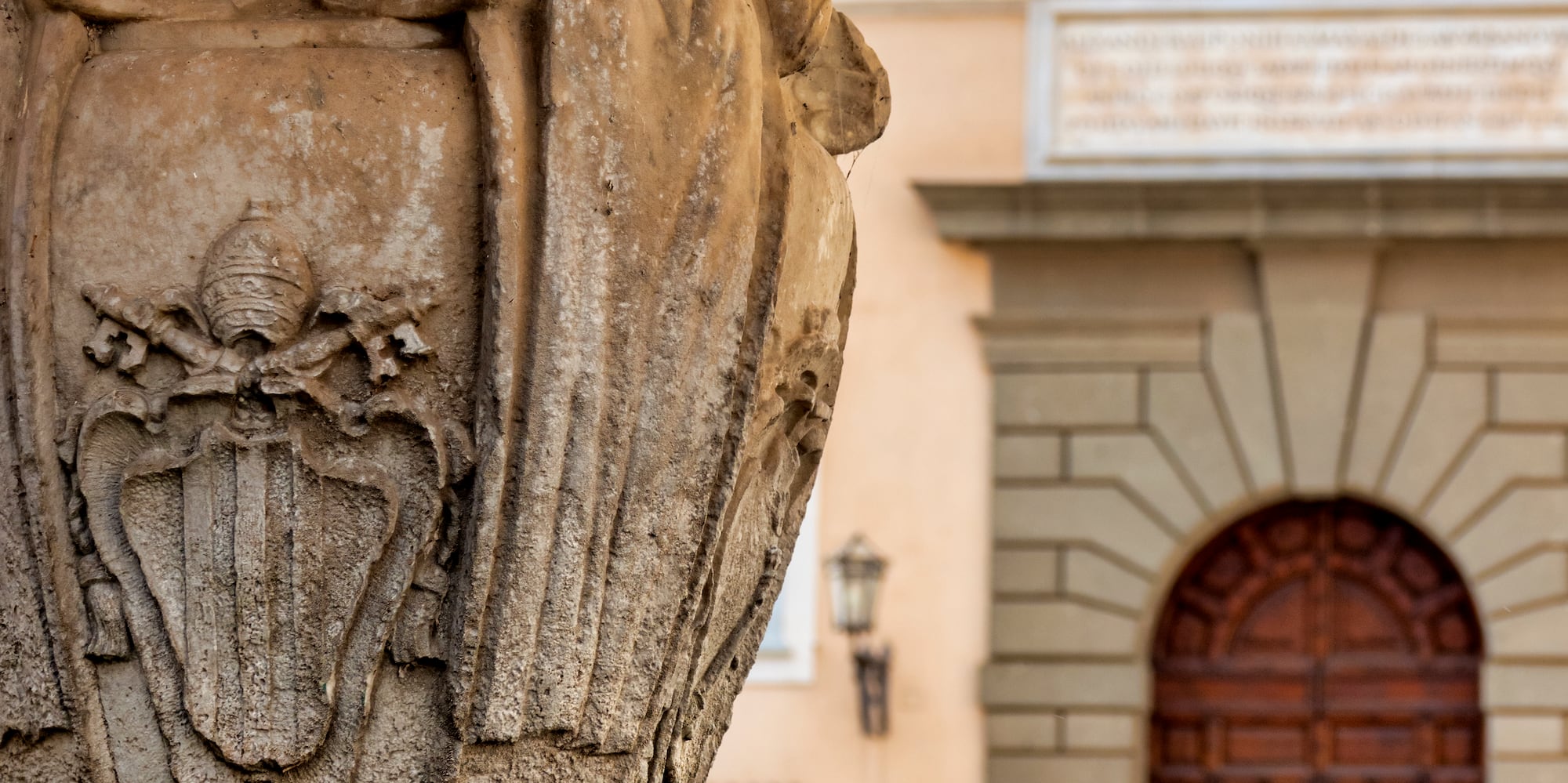 a stone pillar with a stone building in the background