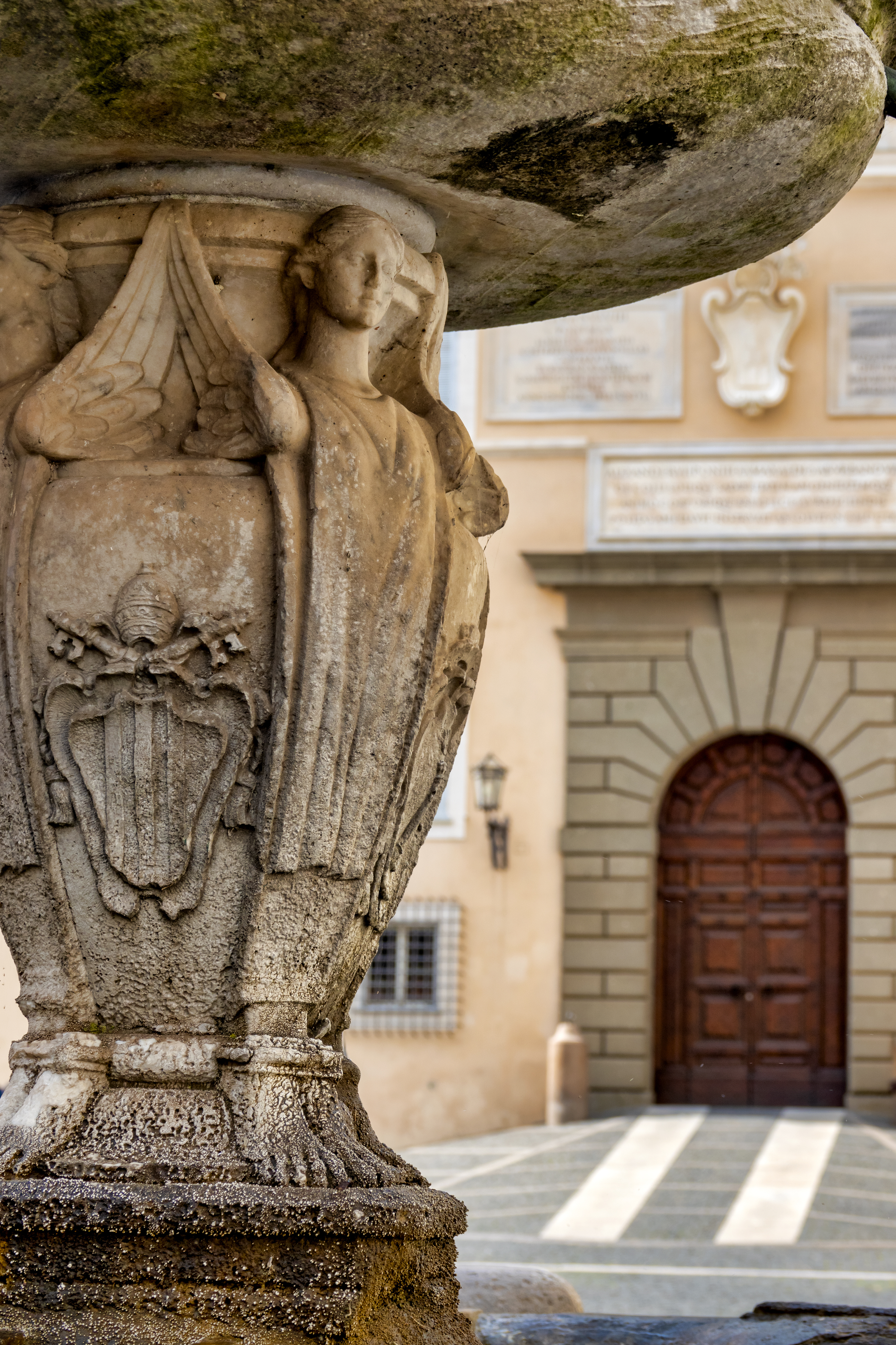 a stone pillar with a stone building in the background