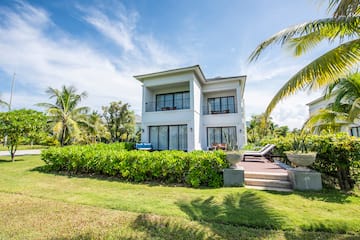 a house with a lawn and palm trees