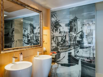 a bathroom with a mirror and a picture of a boat