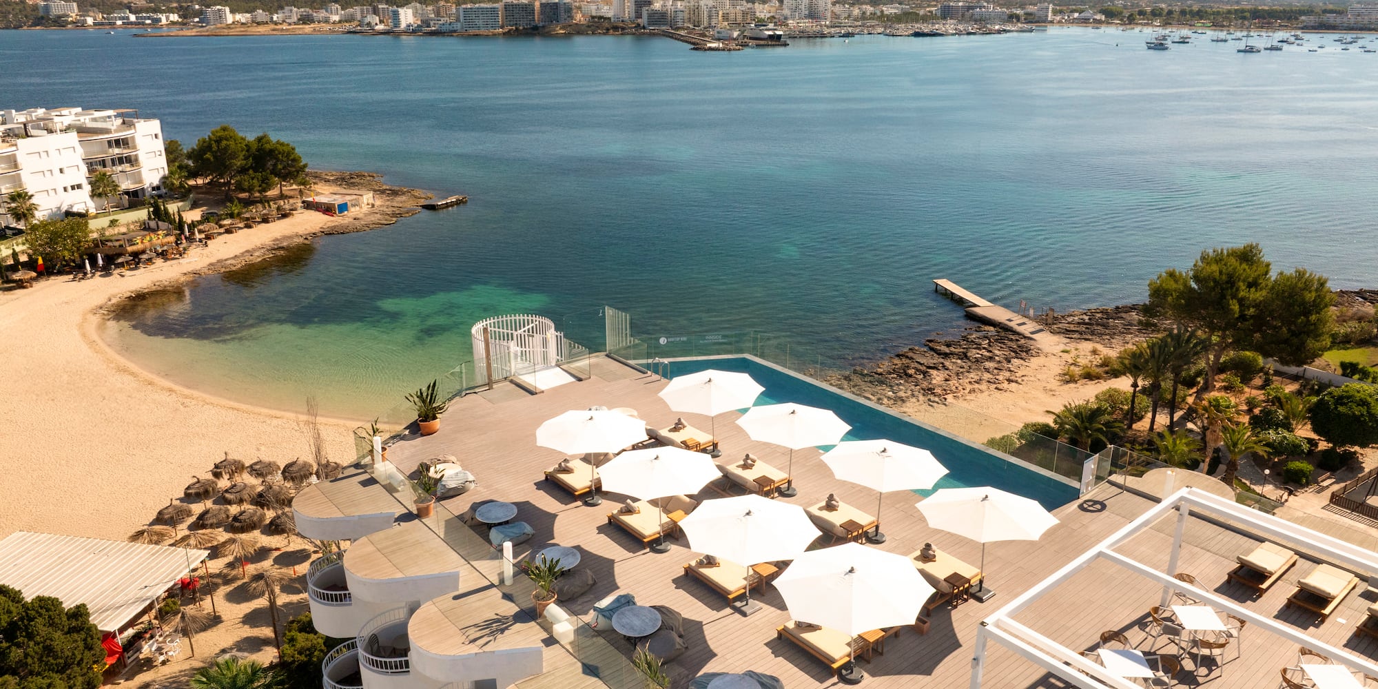 a beach with umbrellas and chairs and a body of water