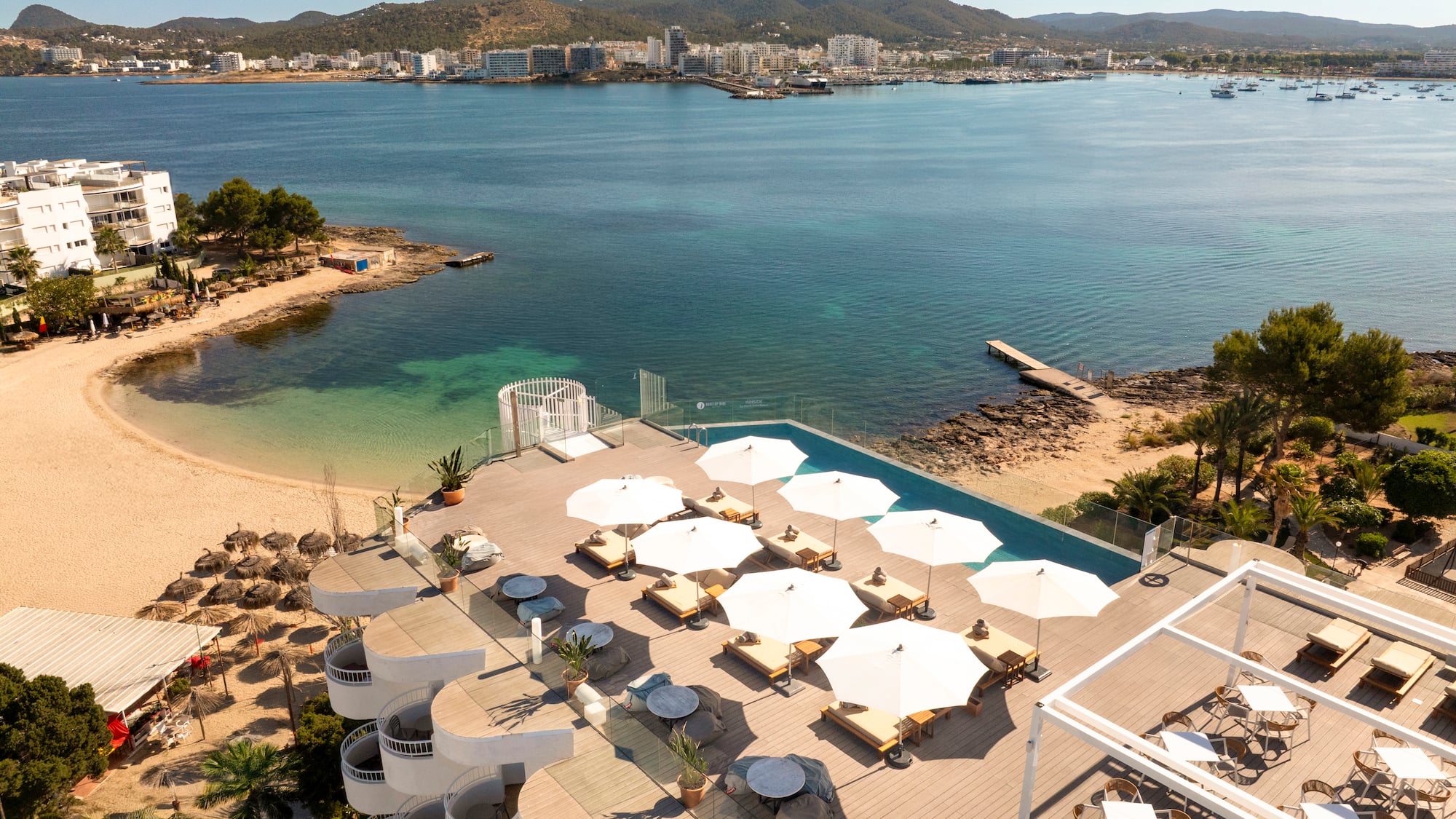 a beach with umbrellas and chairs and a body of water