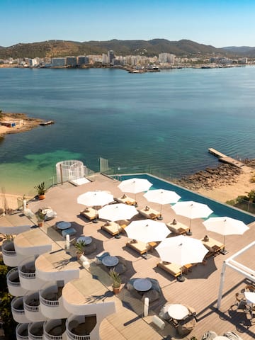 a beach with umbrellas and chairs and a body of water