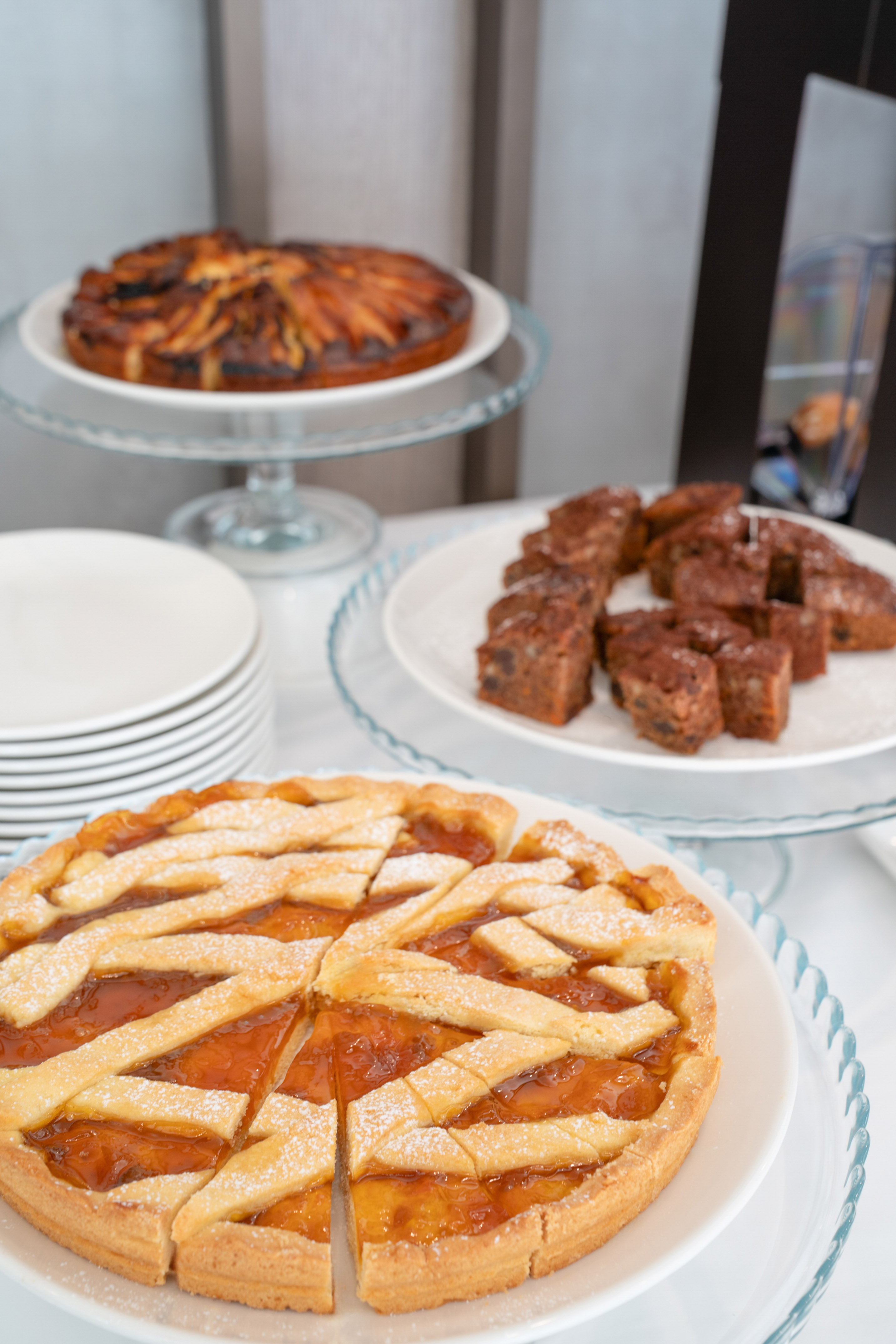 Lattice fruit tart, brownies, and apple tart on a dessert table.