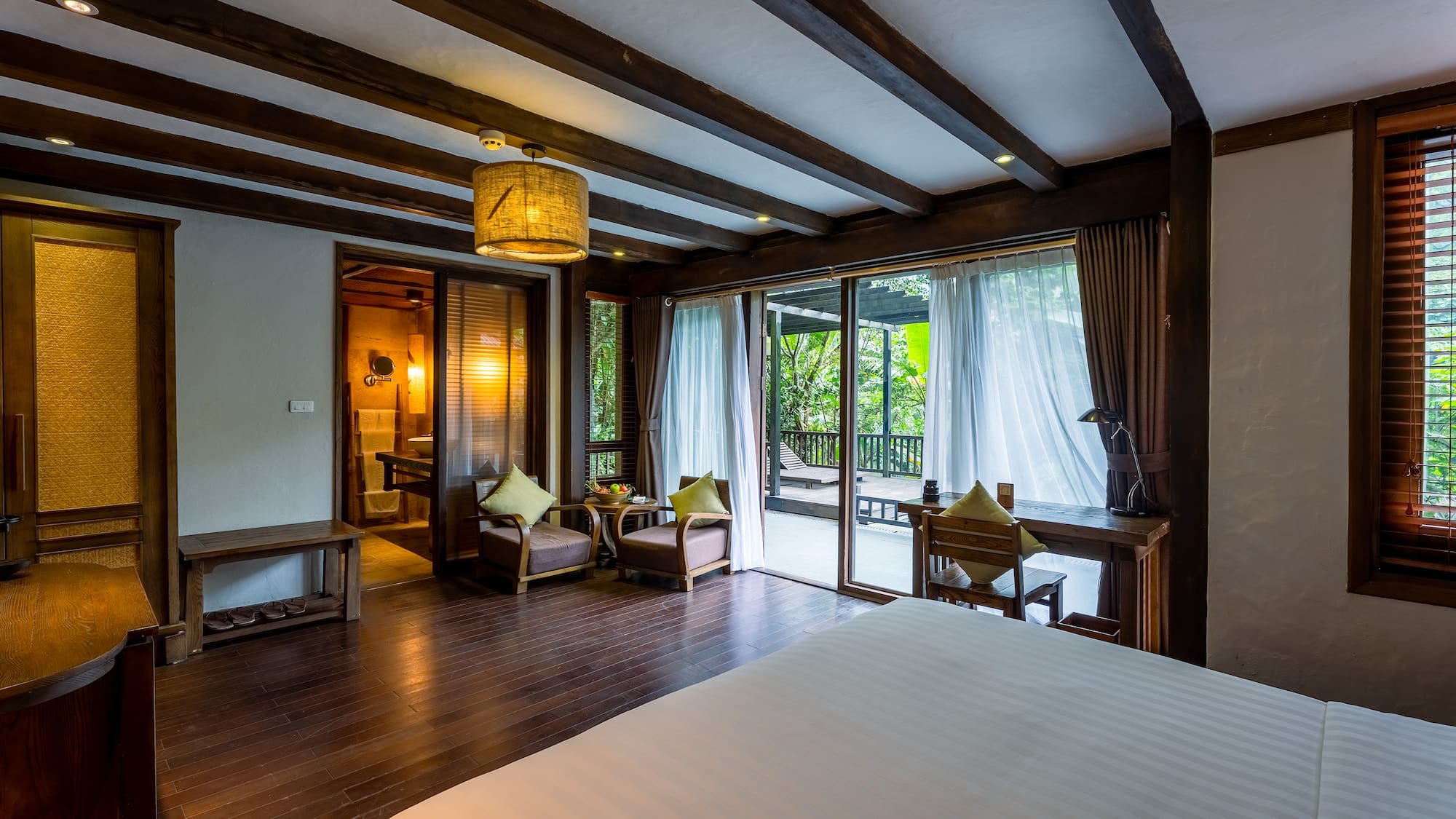 a room with a bed and chairs