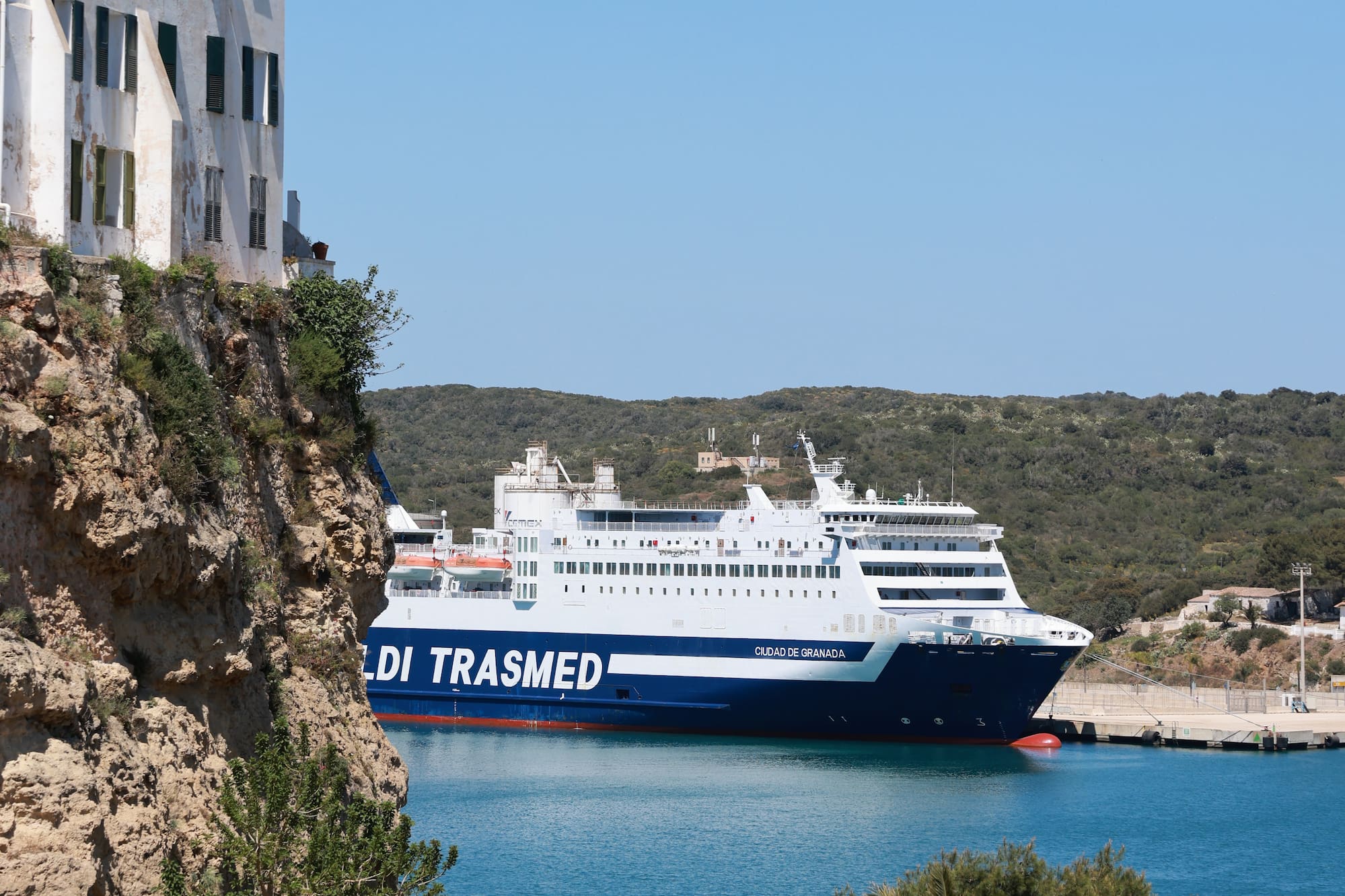 Blue Trasmed ferry 'Ciudad de Granada' in a sunny Mediterranean port.