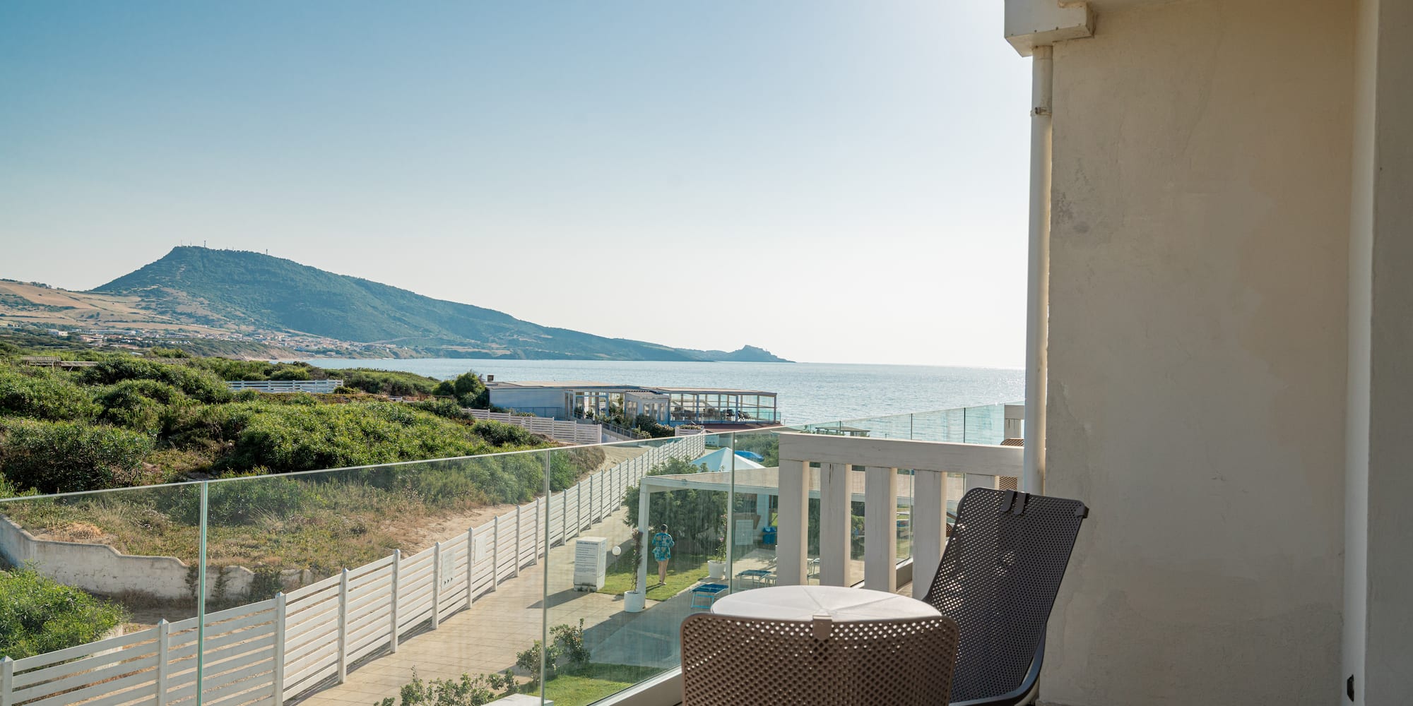 a chair and table on a balcony overlooking a body of water